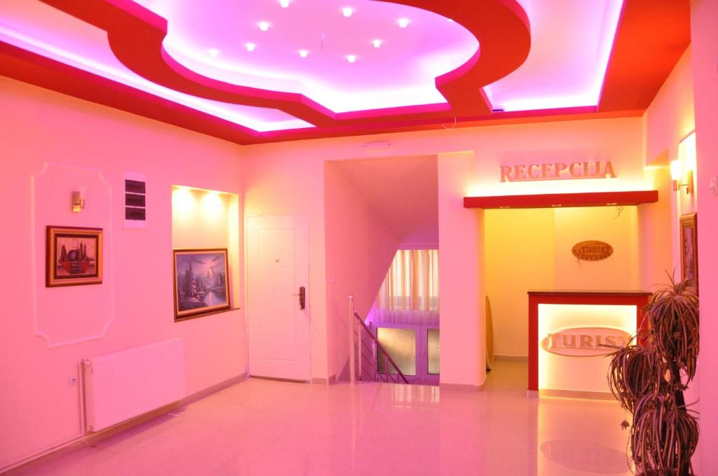 弗拉迪欽漢的住宿－Rooms Turist，走廊设有粉红色和黄色的墙壁和 ⁇ 虹灯天花板