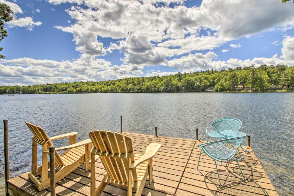 two chairs and a table on a dock on a lake at Waterfront Escape with Kayak, Paddle Boards, and Sauna in Casco