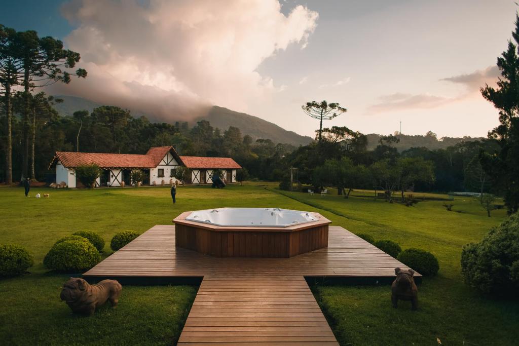 bañera de hidromasaje en una terraza de madera en un campo en Pousada Röhsler en Monte Verde