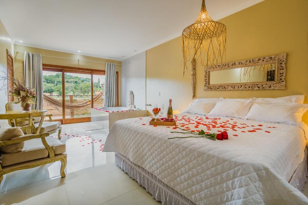 Un dormitorio con una cama con rosas. en Pousada Paraíso Gaia, en Praia do Rosa