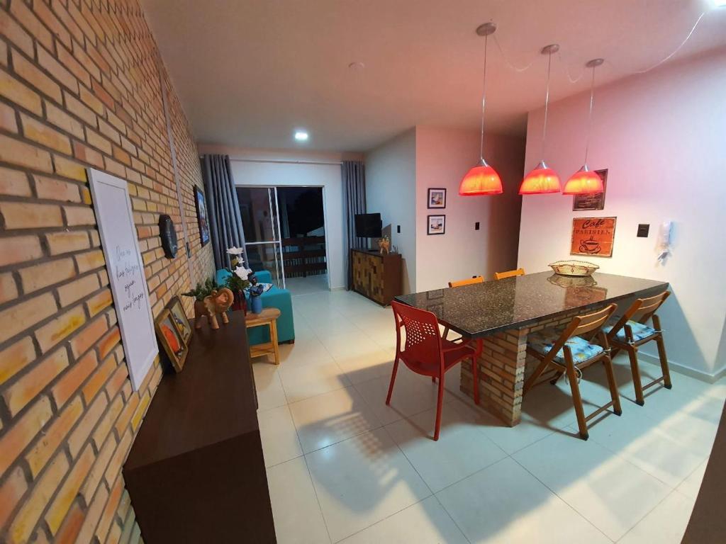 a living room with a table and a brick wall at Apartamento aconchegante em Luis Correia in Luis Correia