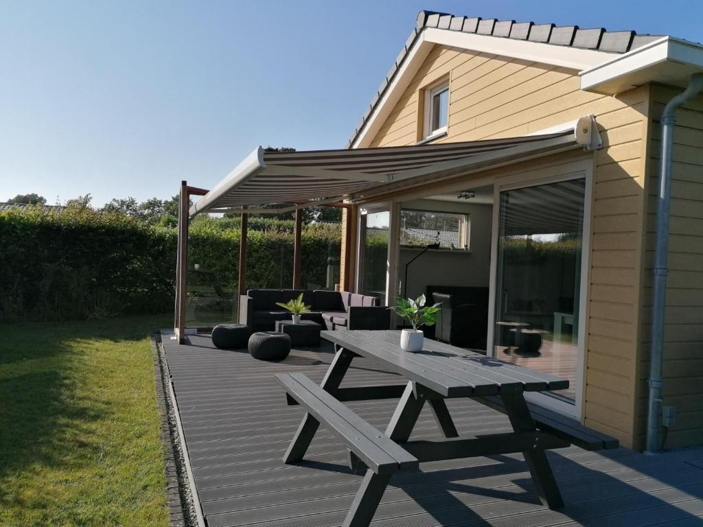 a wooden deck with a picnic table and a pergola at Bright Holiday Home in Noordwijk near Sea in Noordwijk