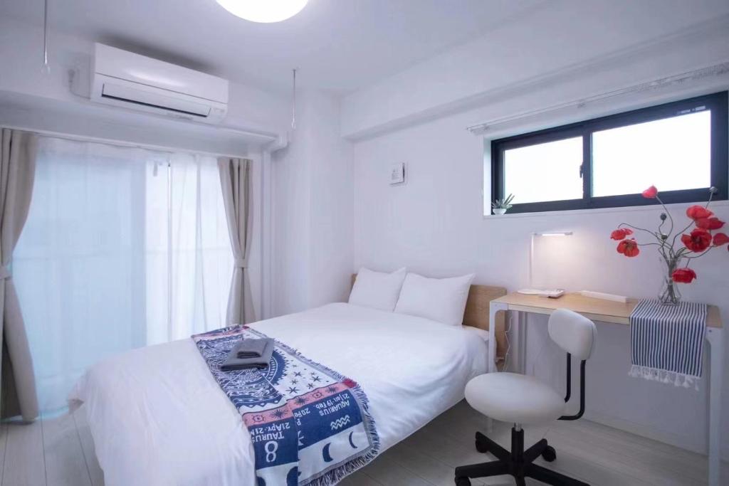 Schlafzimmer mit einem Bett, einem Schreibtisch und einem Fenster in der Unterkunft japan house sugamo in Tokio