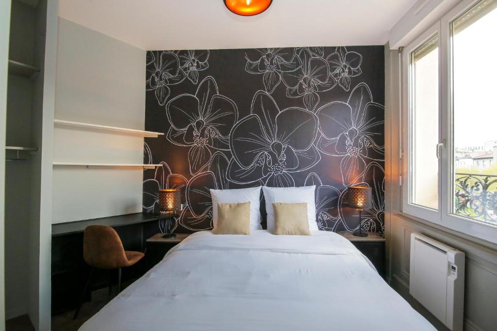 - une chambre avec un grand lit et du papier peint floral dans l'établissement Le Vintage, T2 hypercentre chic et cosy, Wifi par SOVALFI, à Saint-Étienne