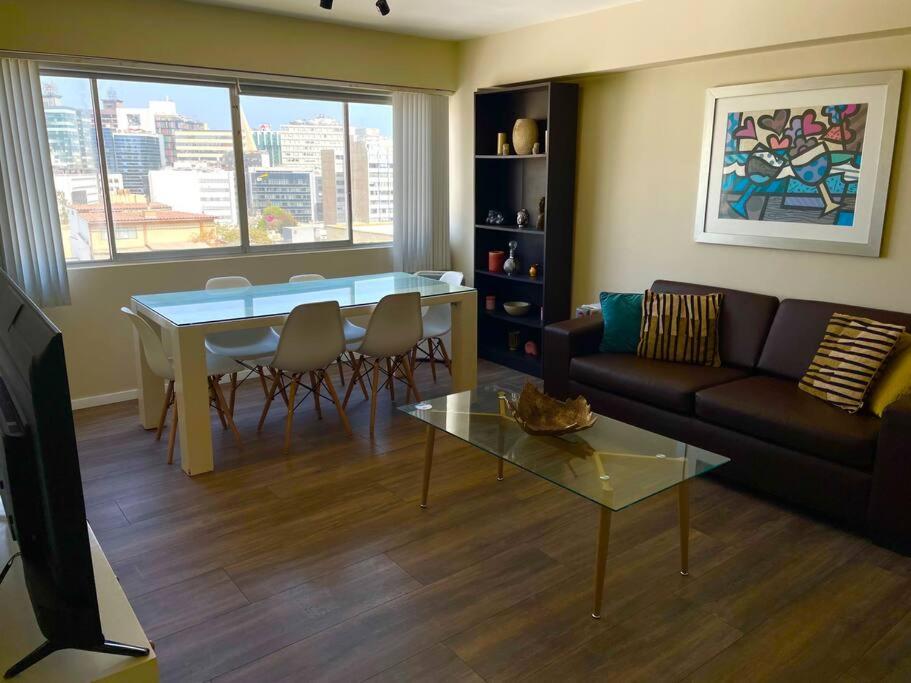 sala de estar con sofá y mesa en Cómodo y céntrico Apartamento en San Isidro, en Lima