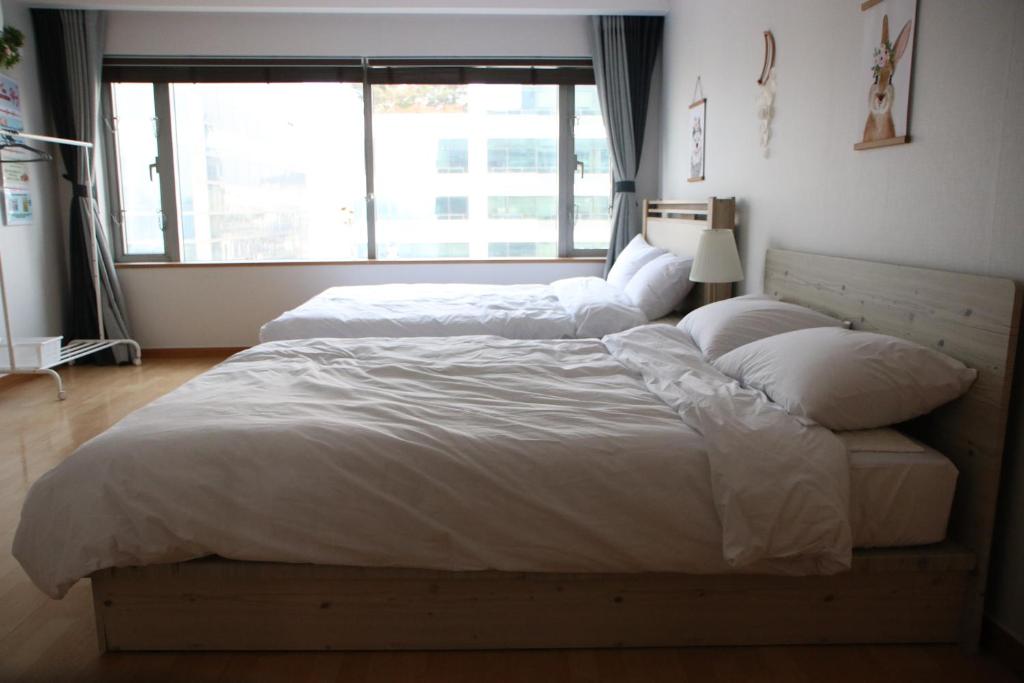 um quarto com 2 camas e uma grande janela em Hongdae Residence-2 1min from Hongik Uni station Exit #1 em Seul