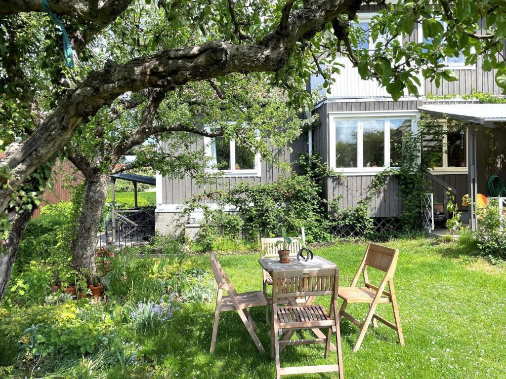 a table and chairs under a tree in a yard at Holiday home LINKÖPING II in Linköping