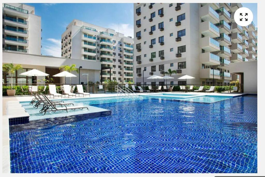 una gran piscina frente a un edificio en Apartamento Padrão em condominio completo no Recreio, en Río de Janeiro