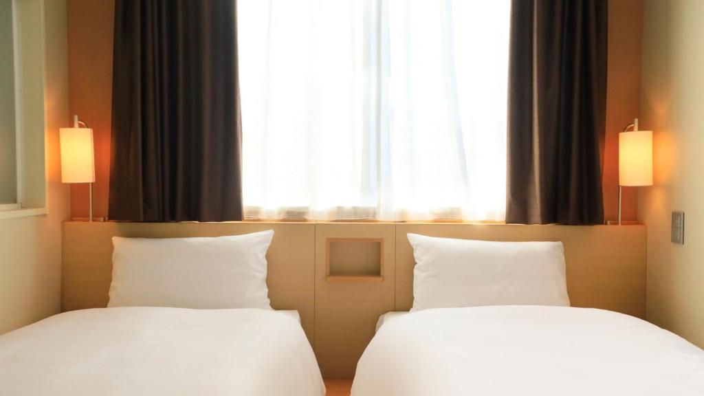 Postel nebo postele na pokoji v ubytování Via Inn Shinjuku
