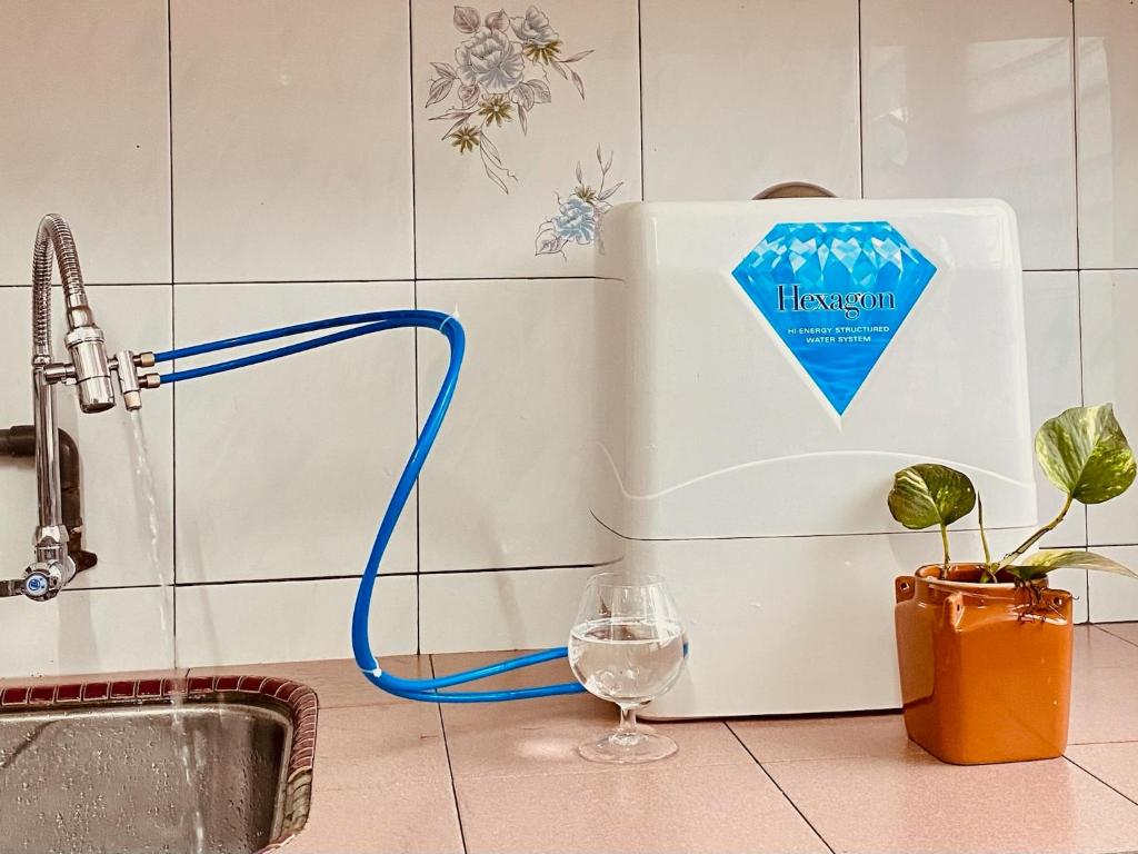 a water fountain in a kitchen with a wine glass at Angel Spa Garden's Homestay in Ipoh