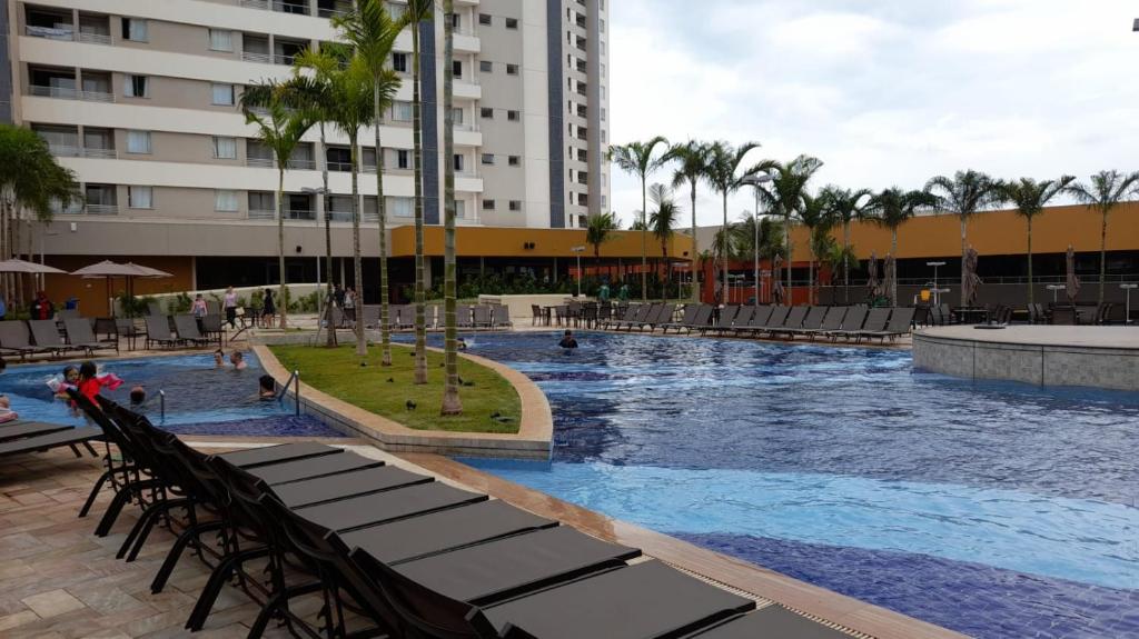 a large swimming pool in a resort with palm trees at Solar das Águas Park Resort in Olímpia