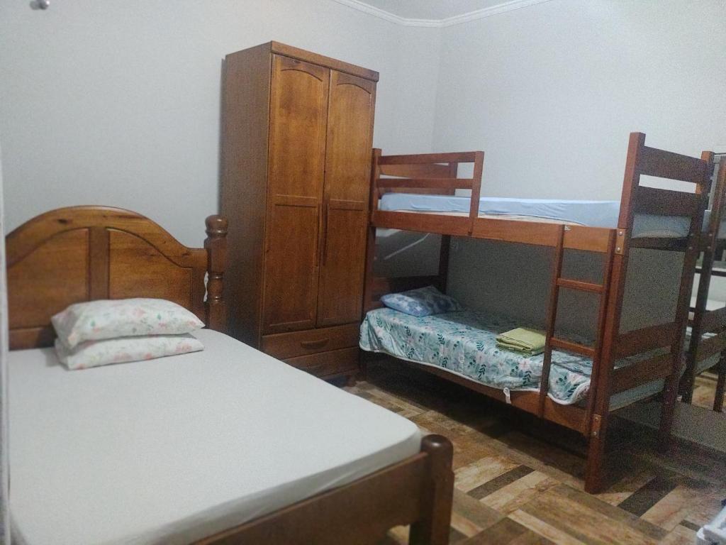 a bedroom with two bunk beds and a cabinet at Pousada do Gelão in Lagoinha