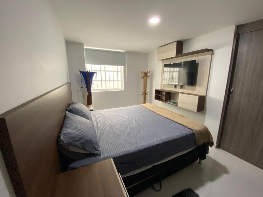 sypialnia z łóżkiem i telewizorem z płaskim ekranem w obiekcie Conquistadores Romantic, Medellín w mieście Medellín