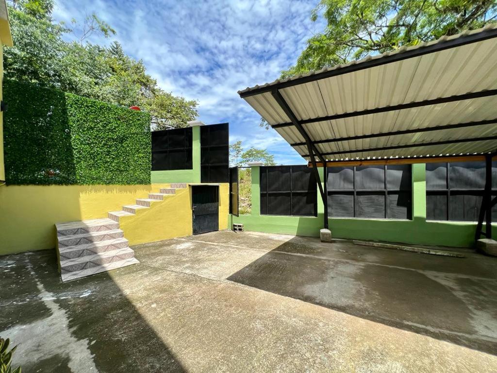 a building with a yellow and green wall and stairs at Yellow House in Quepos