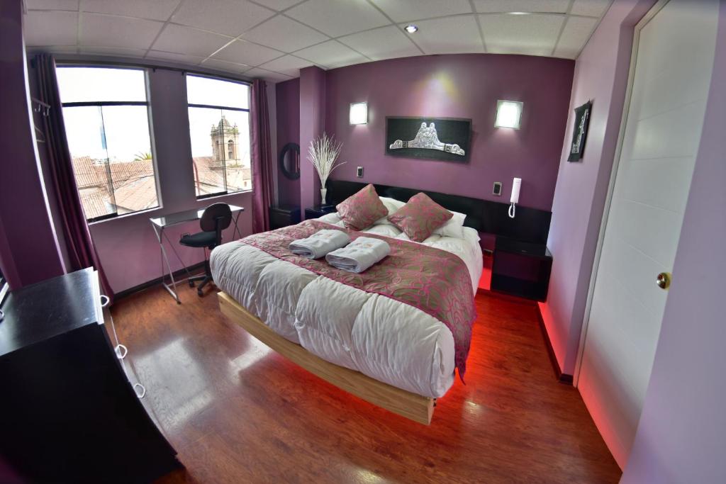 a bedroom with a large bed with purple walls at Wifala Thematic Hotel Boutique in Cusco
