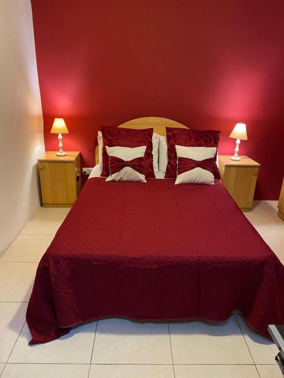 a red bedroom with a large bed with red walls at Valletta Private Room in Valletta