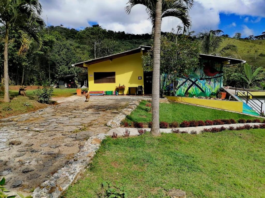 een geel huis met een palmboom ervoor bij Finca Hotel La Vida es un Paseo in San Carlos