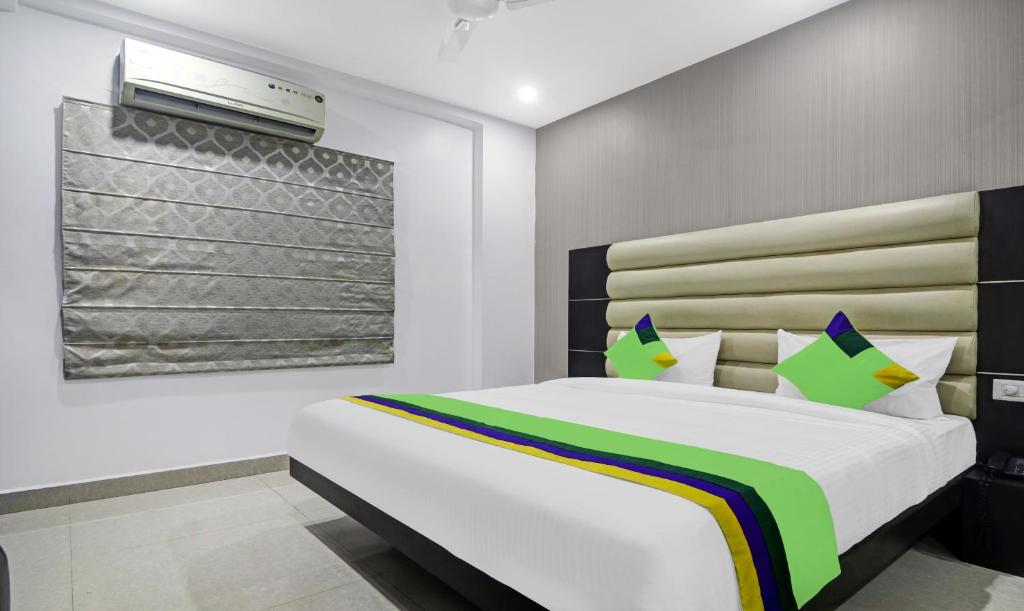 a bedroom with a white bed with avertisementatronatronatronstrationstration at Treebo Trend Kruthika Residency in Hyderabad