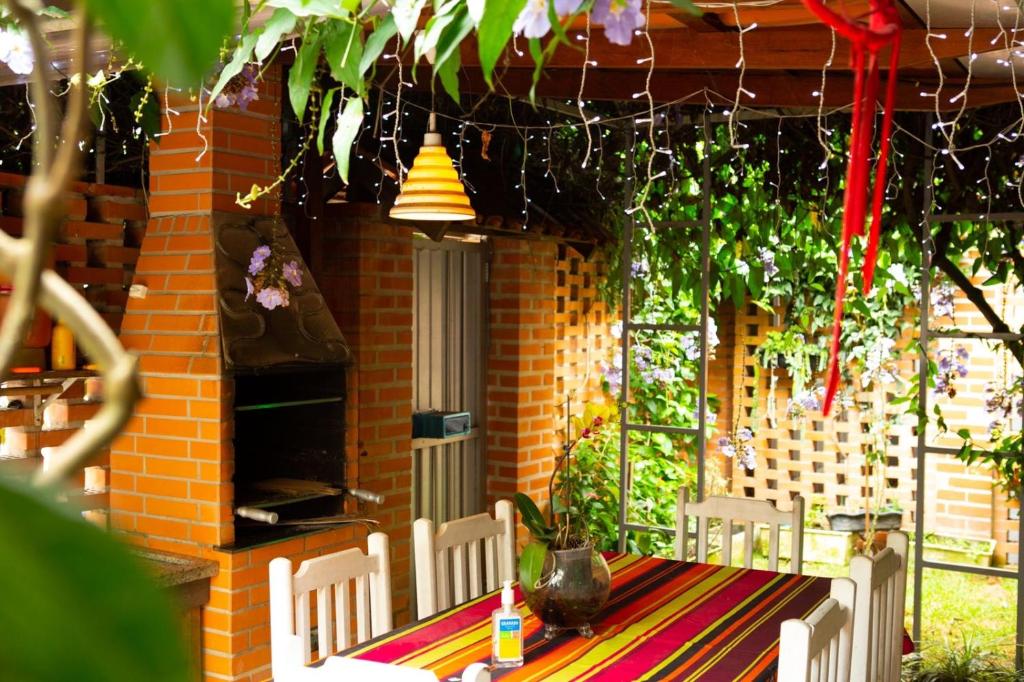 uma mesa e cadeiras em frente a uma casa de tijolos em Villa Di Loire no Balneário Camboriú
