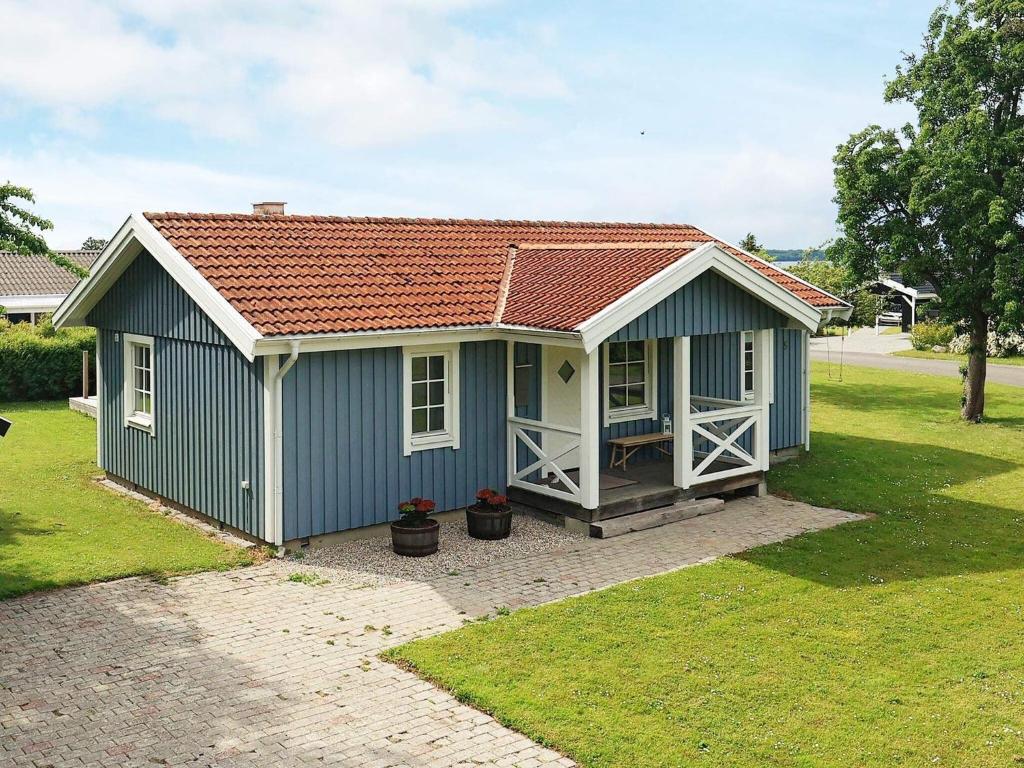 um barracão azul com um telhado vermelho em Holiday home Svendborg XIII em Svendborg
