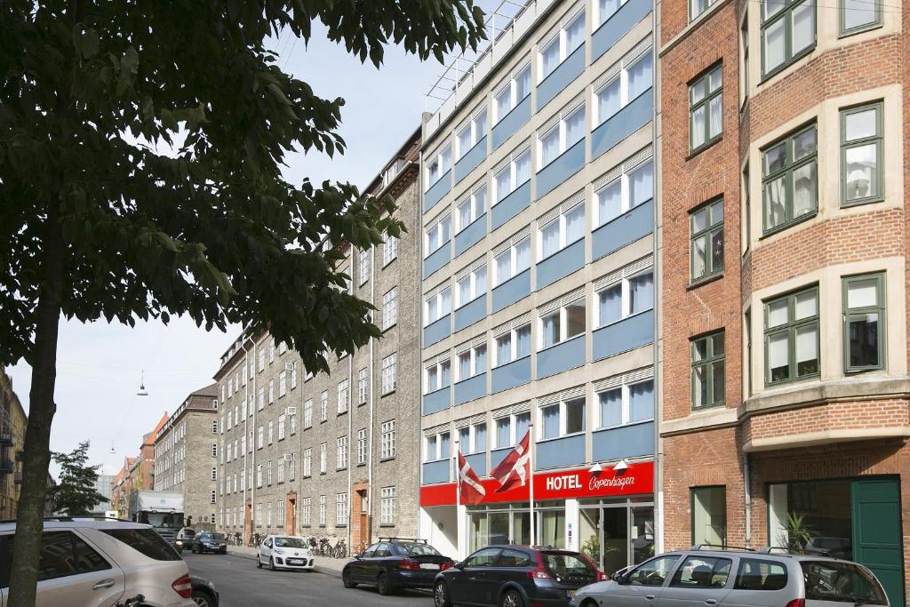 a building with cars parked in front of it at Hotel Copenhagen Apartments in Copenhagen