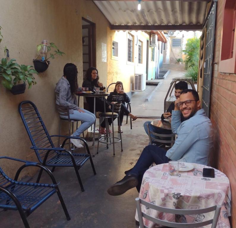 a group of people sitting at a table in a restaurant at Pousada Recanto Alaketu Hospedagens in Campo Grande