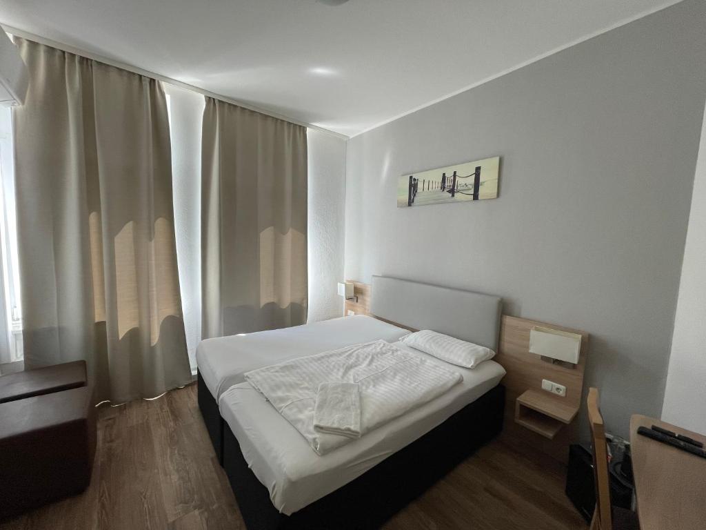 a small bedroom with a bed and a window at Central Hotel Duisburg in Duisburg