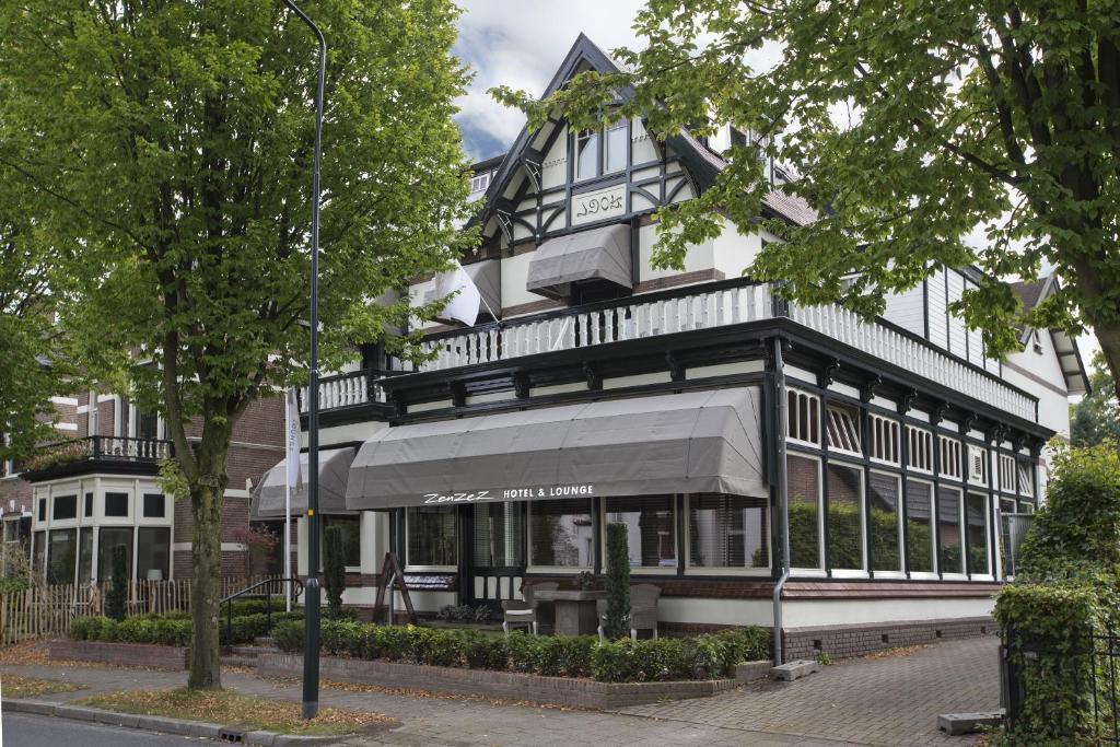 un grand bâtiment noir et blanc avec un magasin dans l'établissement Zenzez Hotel & Lounge, à Apeldoorn