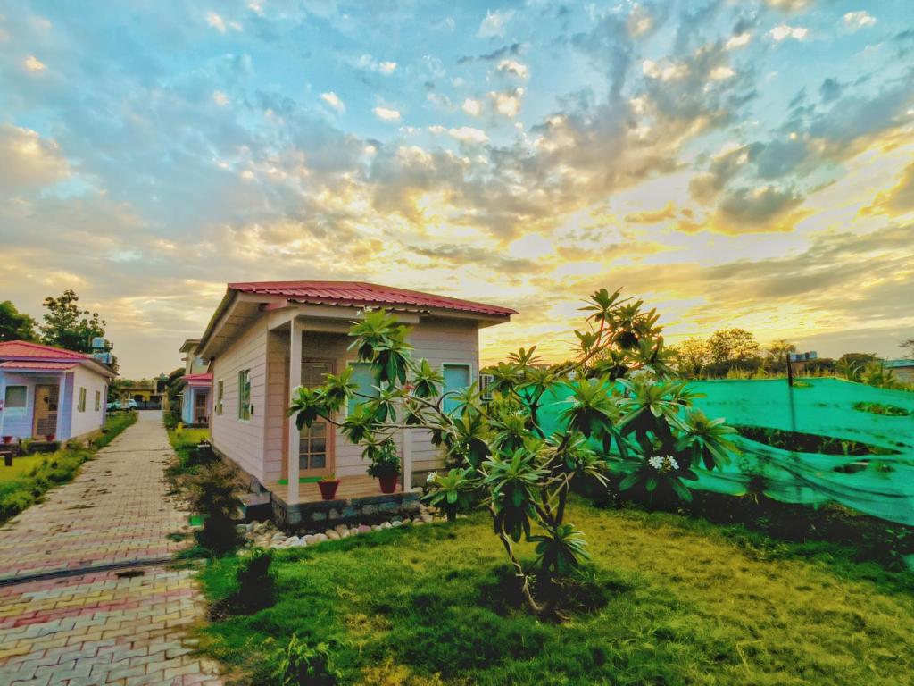 a row of houses in a yard with a brick road at Corbett VEDA INN in Rāmnagar