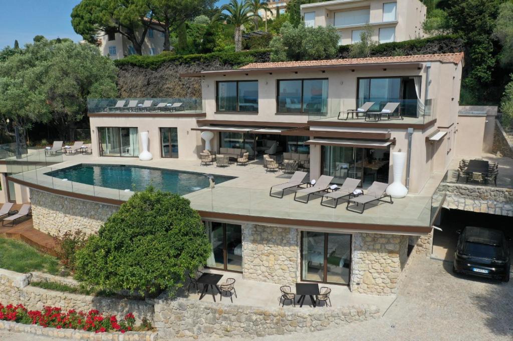 una casa con una piscina di fronte di Villa Paulina MOUGINS a Mougins