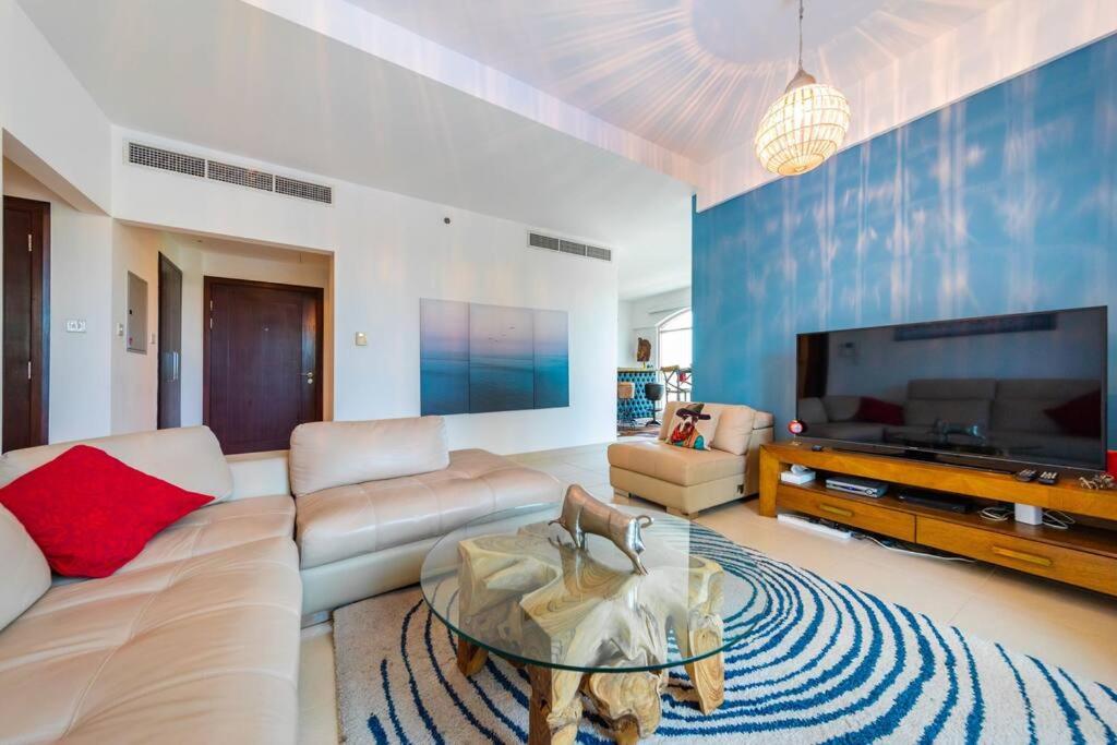 a living room with a large flat screen tv at Tanaro, The Views by Emaar - Mint Stay in Dubai