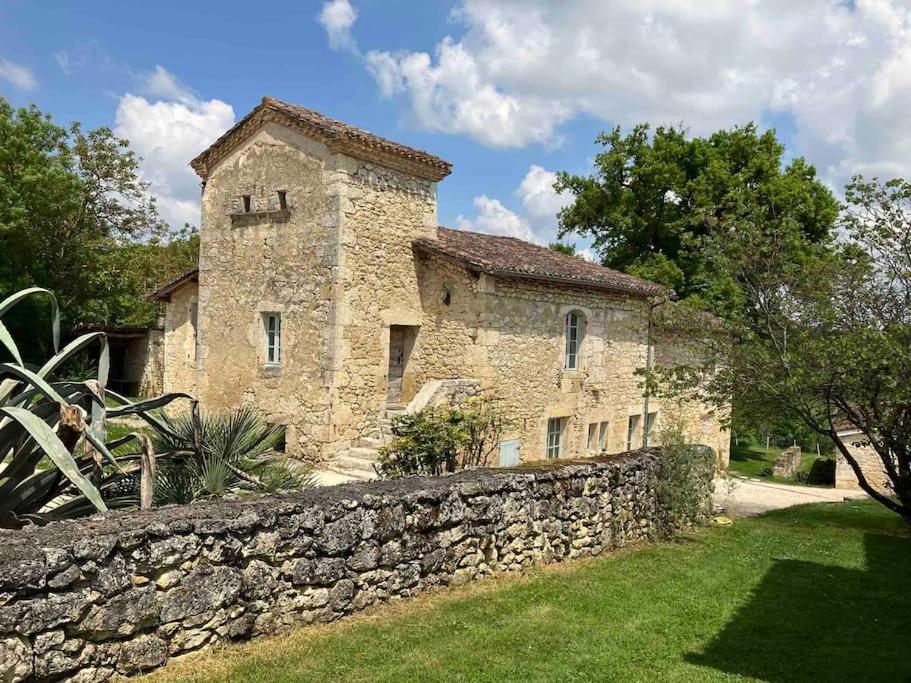 ein altes Steingebäude mit einer Steinmauer in der Unterkunft Gite de charme avec piscine - a charming cottage gite with swimming pool in Saint-Léonard