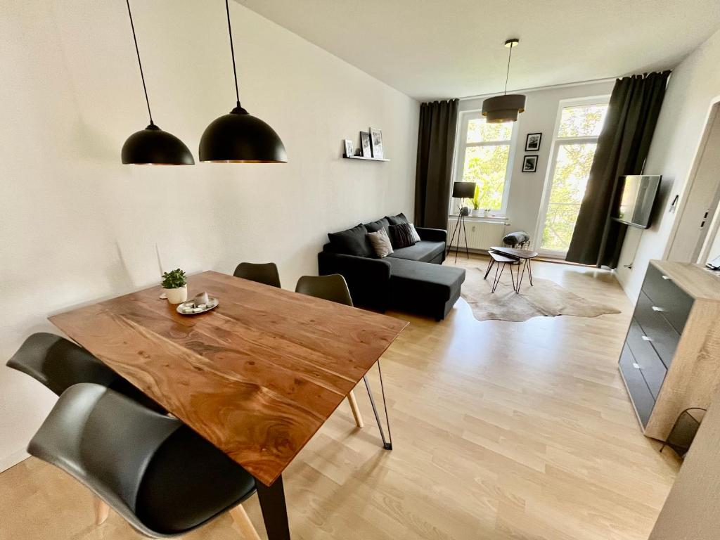 a living room with a wooden table and a couch at Purer Luxus mit 2 Schlafzimmern, Balkon und Privat-Parkplatz in Leipzig