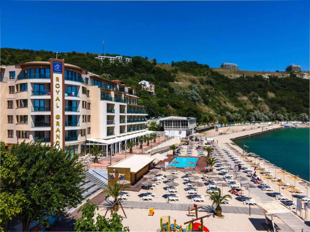 una playa con sillas y sombrillas y un complejo en Royal Grand Hotel and Spa - All Inclusive and Free beach accsess, en Kavarna