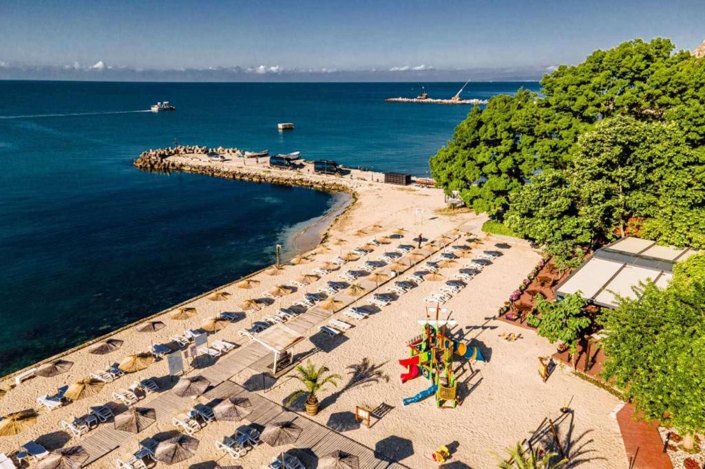 カヴァルナにあるRoyal Grand Hotel and Spa - All Inclusive and Free beach accsessのビーチの空中を望む客室で、椅子とパラソルが備わります。
