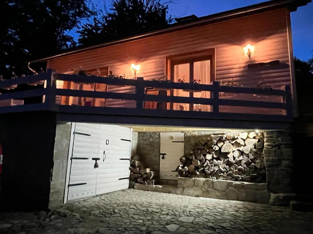 uma casa com garagem à noite com luzes em Dom pod kogutem em Laliki