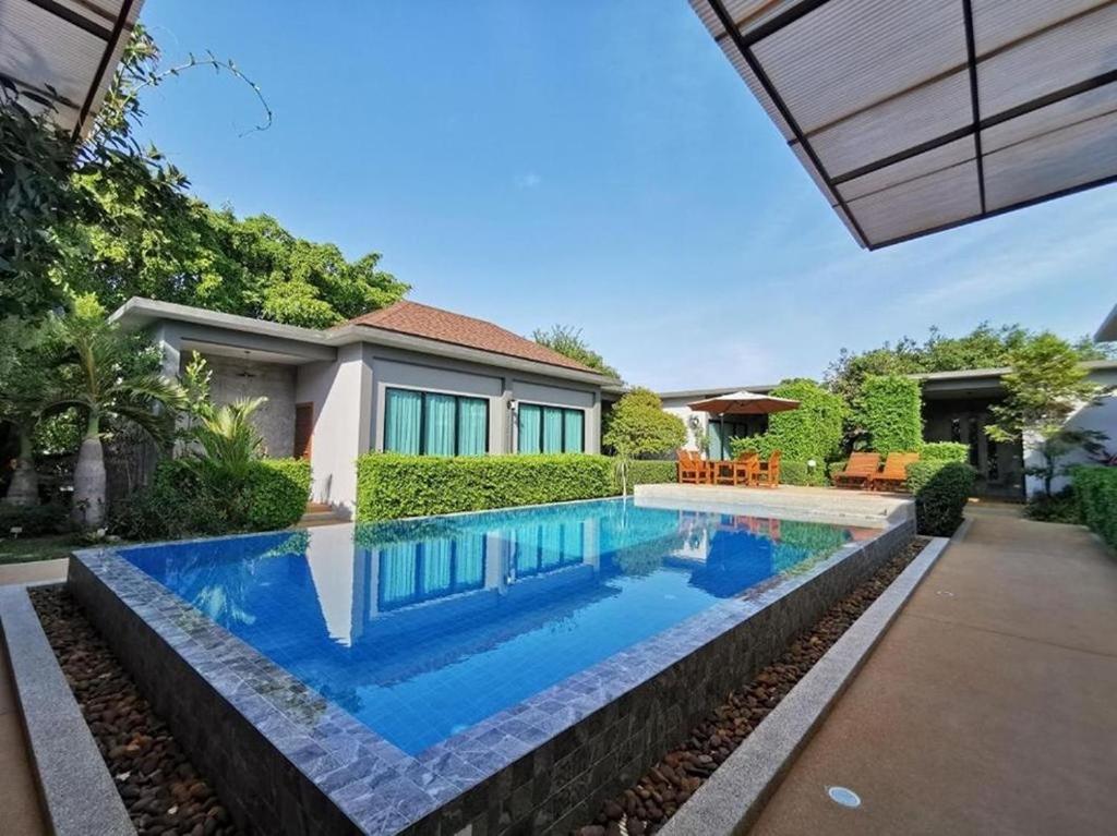 BaanMee Phuket SHA Plus في تشالونج: مسبح في الحديقة الخلفية للمنزل