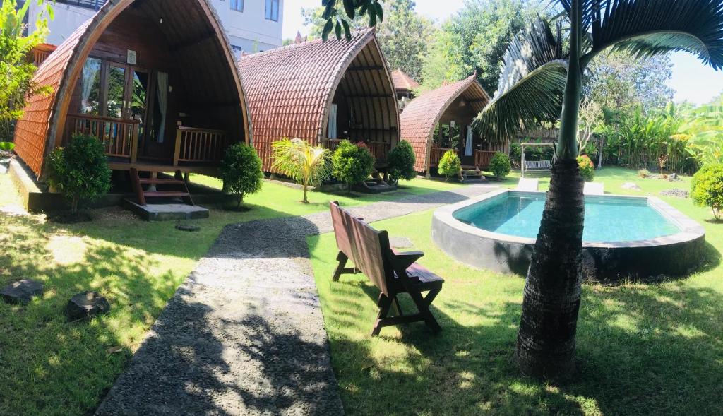 a house with a bench next to a swimming pool at Pondok sari homestay in Ungasan