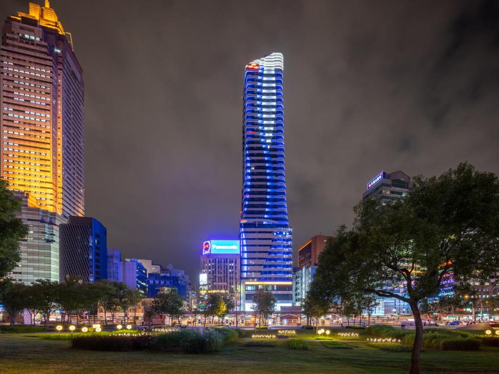 a tall skyscraper in a city at night at Roaders Plus Hotel - Theme in Taipei