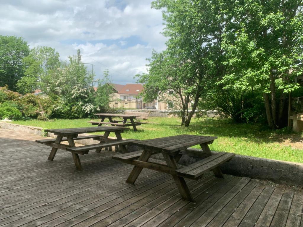 un groupe de tables de pique-nique sur une terrasse en bois dans l'établissement Chez Hervé le Châtelet, à La Chaux Neuve