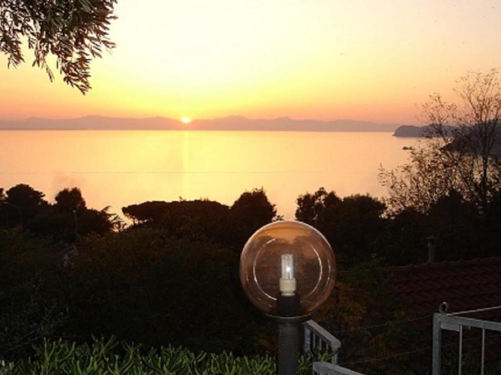 a light in front of a view of a sunset at Fewo Sole e Azzurro in Capoliveri