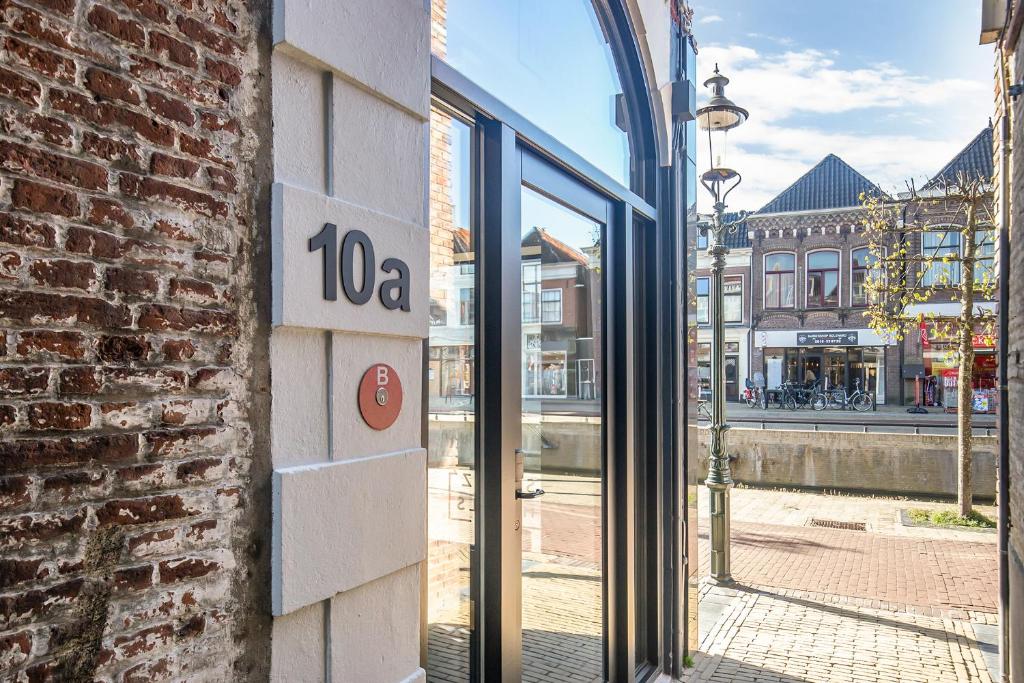 博爾斯瓦德的住宿－Snoozz Hotels Bolsward Boutique hotel zonder receptie met digitale sleutel，通往享有街道景致的建筑的门