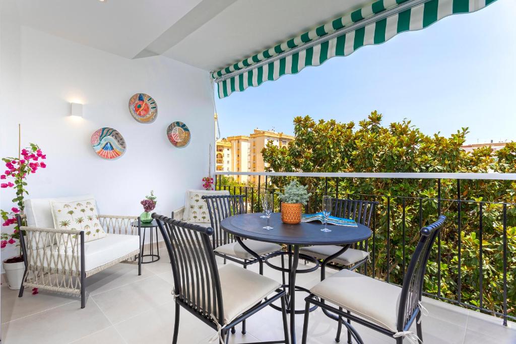 patio con mesa y sillas en el balcón en Genteel Home Ricardo Soriano en Marbella