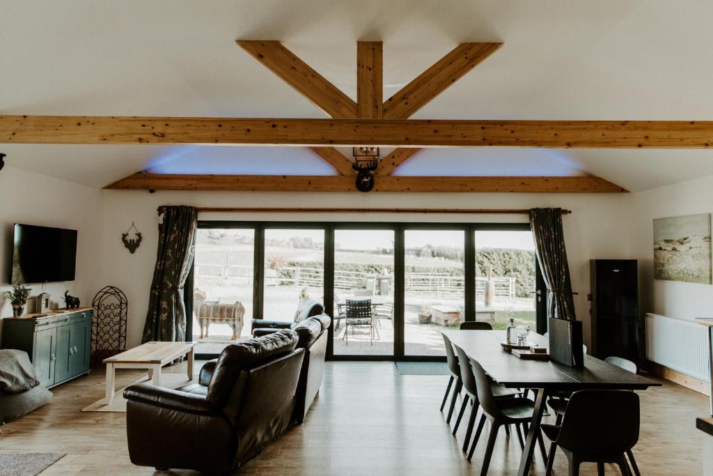 a living room with a table and chairs and a dining room at King Richards Luxury large Lodge sleeps up to 7 Guests at Fairview Farm Near Sherwood Forest in Ravenshead Nottingham set in 88 acres of Farm Land with Great Walks,Views,Pet Animals in Nottingham