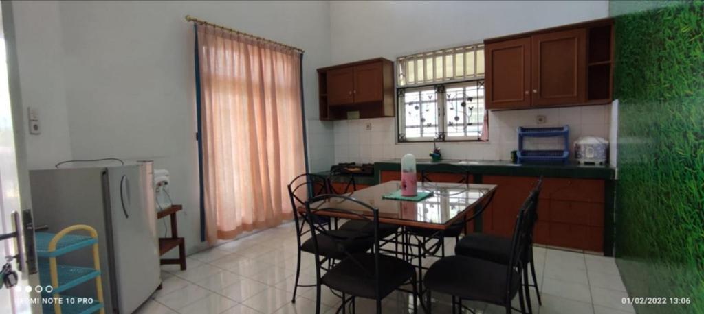 a kitchen with a table and chairs and a refrigerator at Villa Berastagi Mas in Berastagi