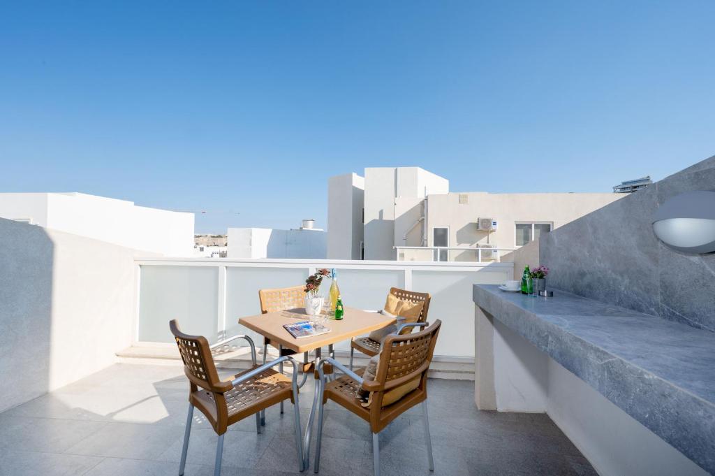 una mesa y sillas en un balcón con vistas en Vela Blu Apartments - Rose Court en Il-Gżira