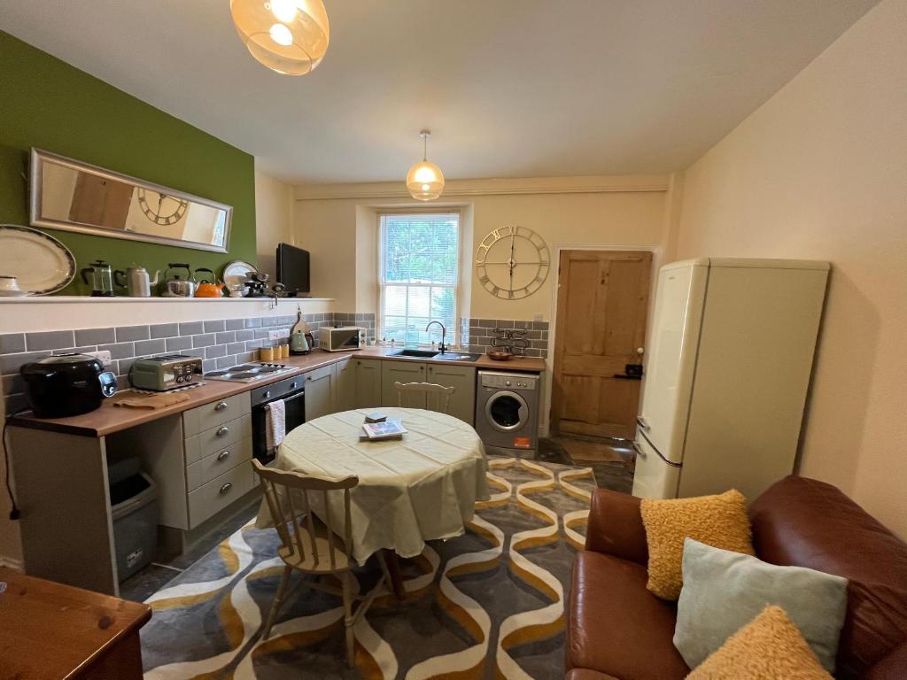 a kitchen with a table in the middle of a room at Coastal cottage ‘The Old Bank’ in Hartland