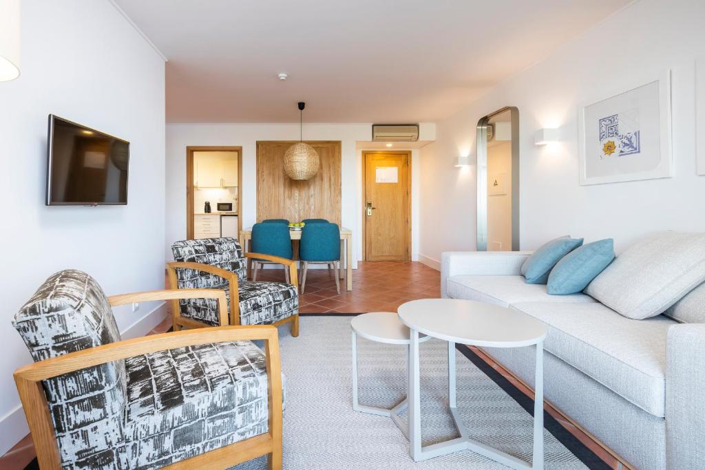 a living room with a couch and chairs and a table at The Patio Suite Hotel in Albufeira