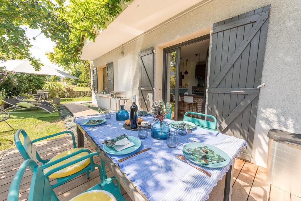 une table avec un chiffon bleu sur une terrasse dans l'établissement Cosy spirit-Proche plage, piste cyclable et centre village, 3ch 3 sdb- Une exclusivité LLA Selections by Location lac Annecy, à Saint-Jorioz