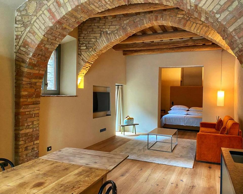 - un salon avec une chambre dotée d'un lit et d'une table dans l'établissement Locanda della Scala, à San Quirico dʼOrcia